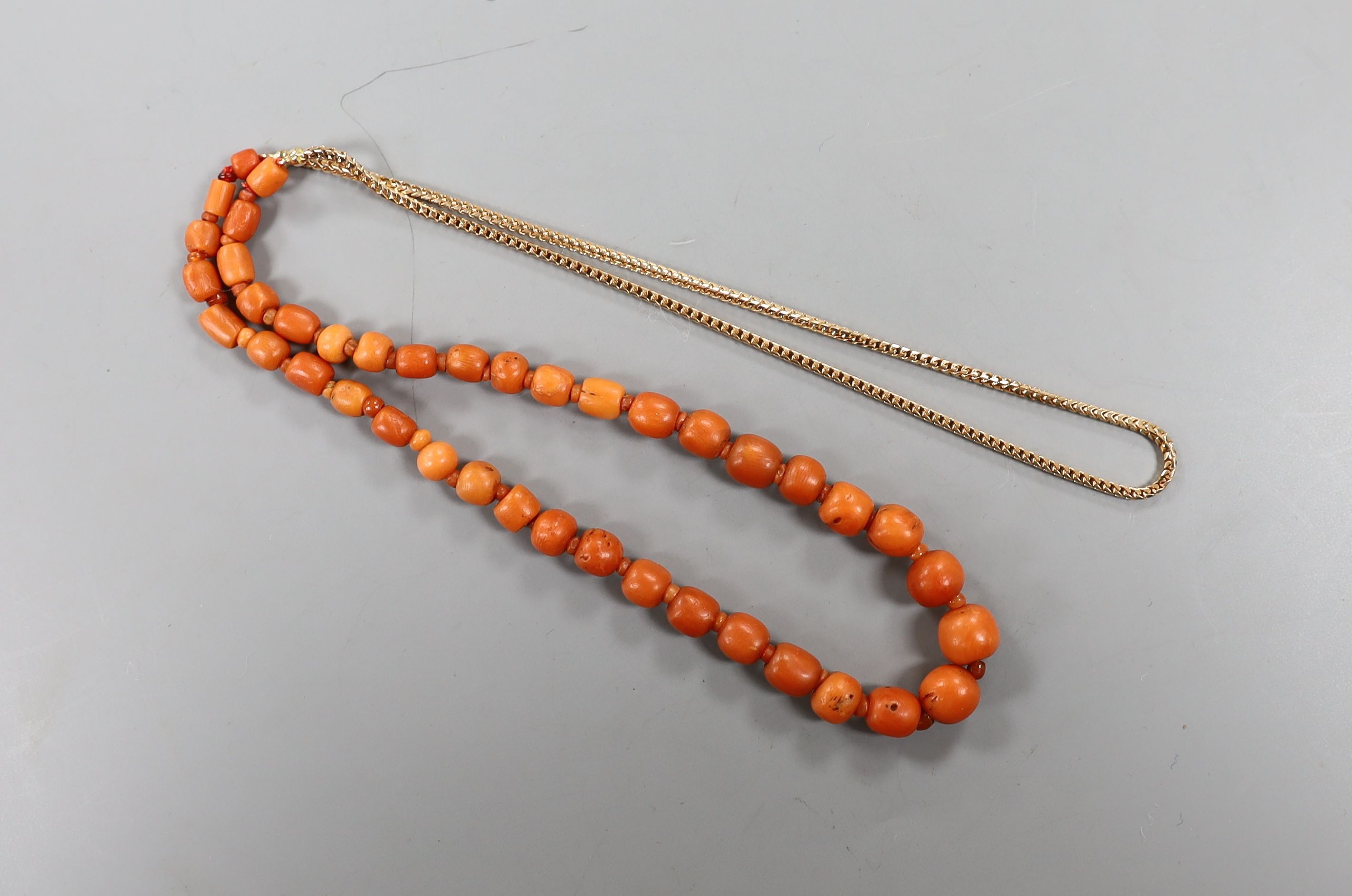 A group of graduated Egyptian coral beads, now strung on a later yellow metal necklace, 62cm